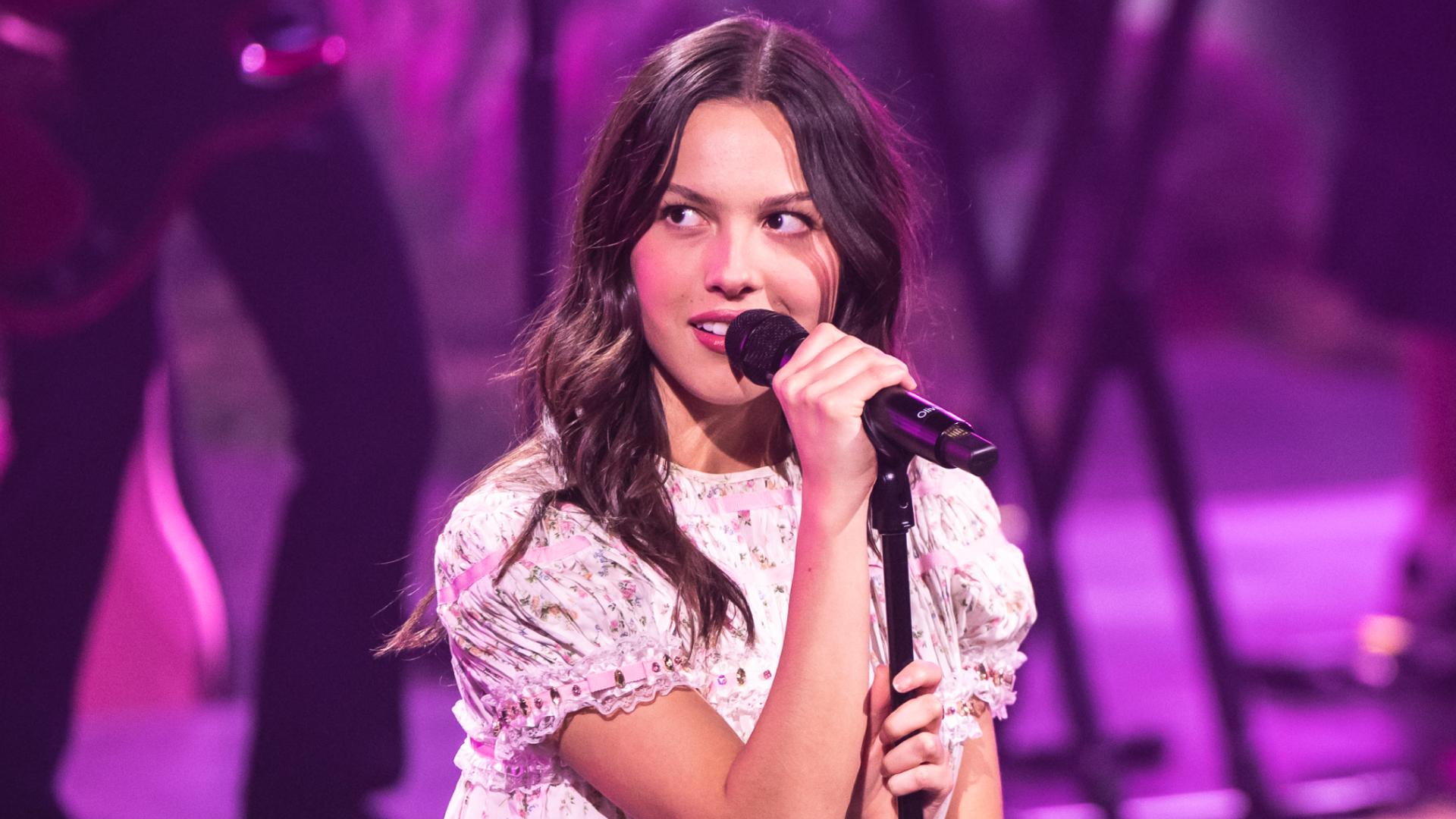 Olivia Rodrigo performs on stage during an exclusive Billions Club Live show to celebrate the partnership between Spotify and FC Barcelona wearing a babydoll floral dress.