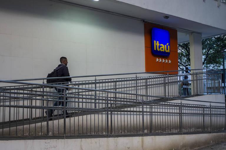 Homem subindo rampa de entrada da agência do banco Itaú