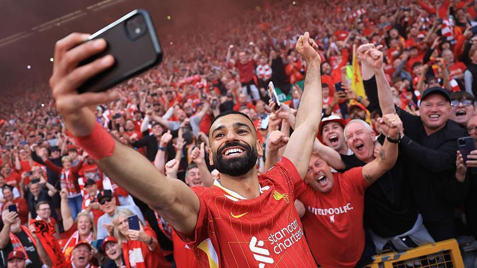 Mohamed Salah tirando um selfie com torcedores do Liverpool