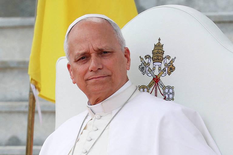 Papa Leão XIV em vestes brancas tradicionais, sentado com brasão papal.