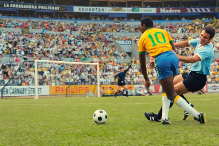 Jogador com a camisa amarela avança com a bola