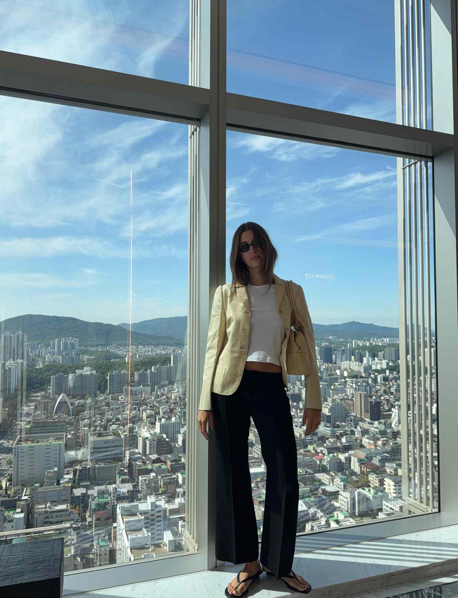 Hailey Bieber posando em frente a uma janela em Seul