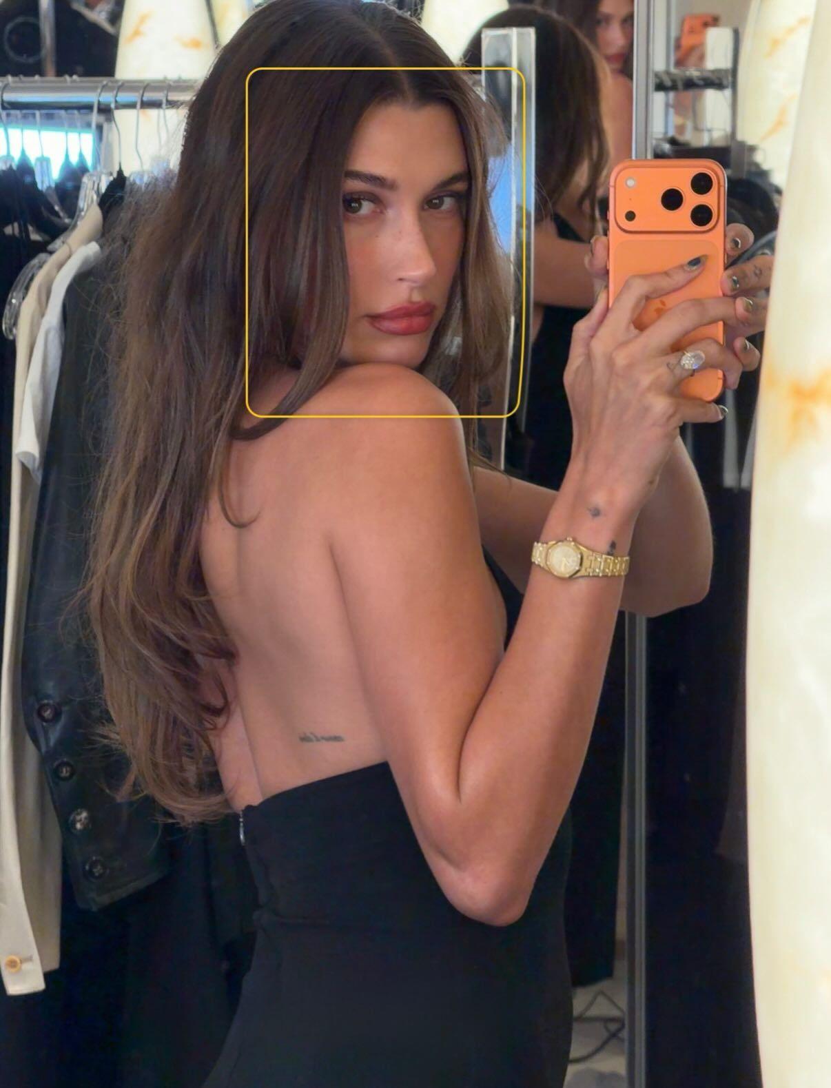 Hailey Bieber em um espelho, usando um vestido halter preto