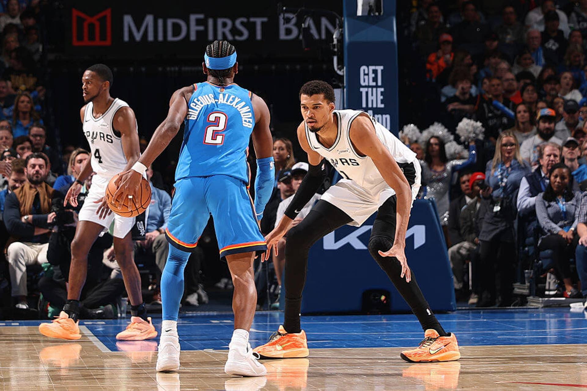 Shai Gilgeous-Alexander e Victor Wembanyama durante um jogo Spurs-Thunder