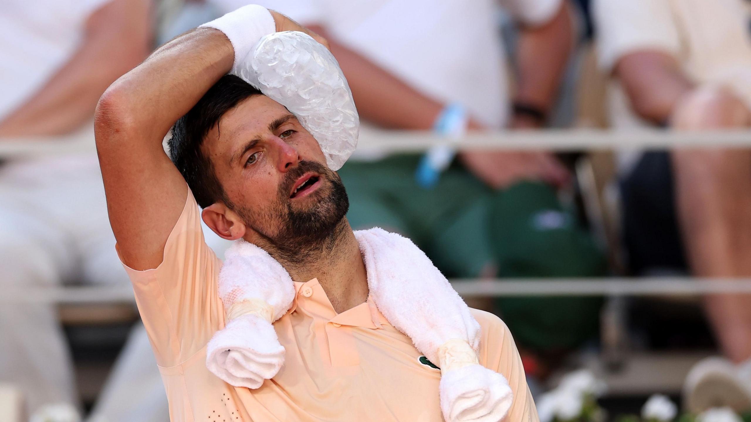 Novak Djokovic usa gelo para se refrescar durante sua partida.
