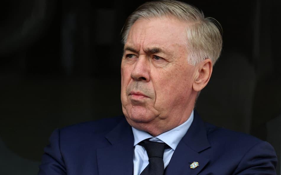 Ancelotti com expressão séria de terno.
