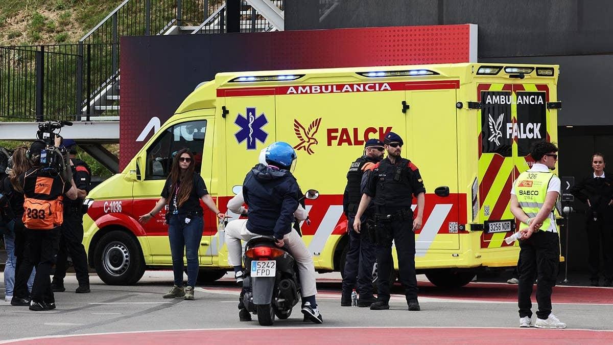 Alex Marquez sentado no chão enquanto uma ambulância chega na pista