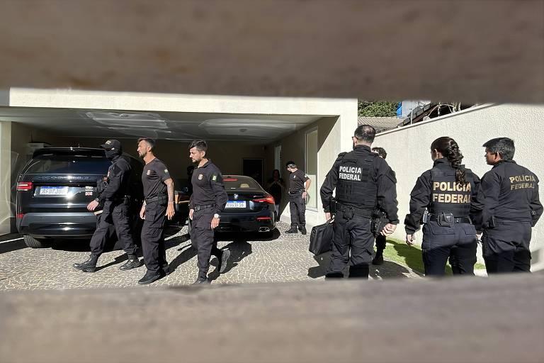 Oito agentes da Polícia Federal, com uniformes pretos e coletes identificados, realizam operação.
