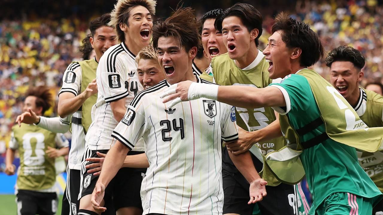 Jogadores de futebol japoneses celebram um gol