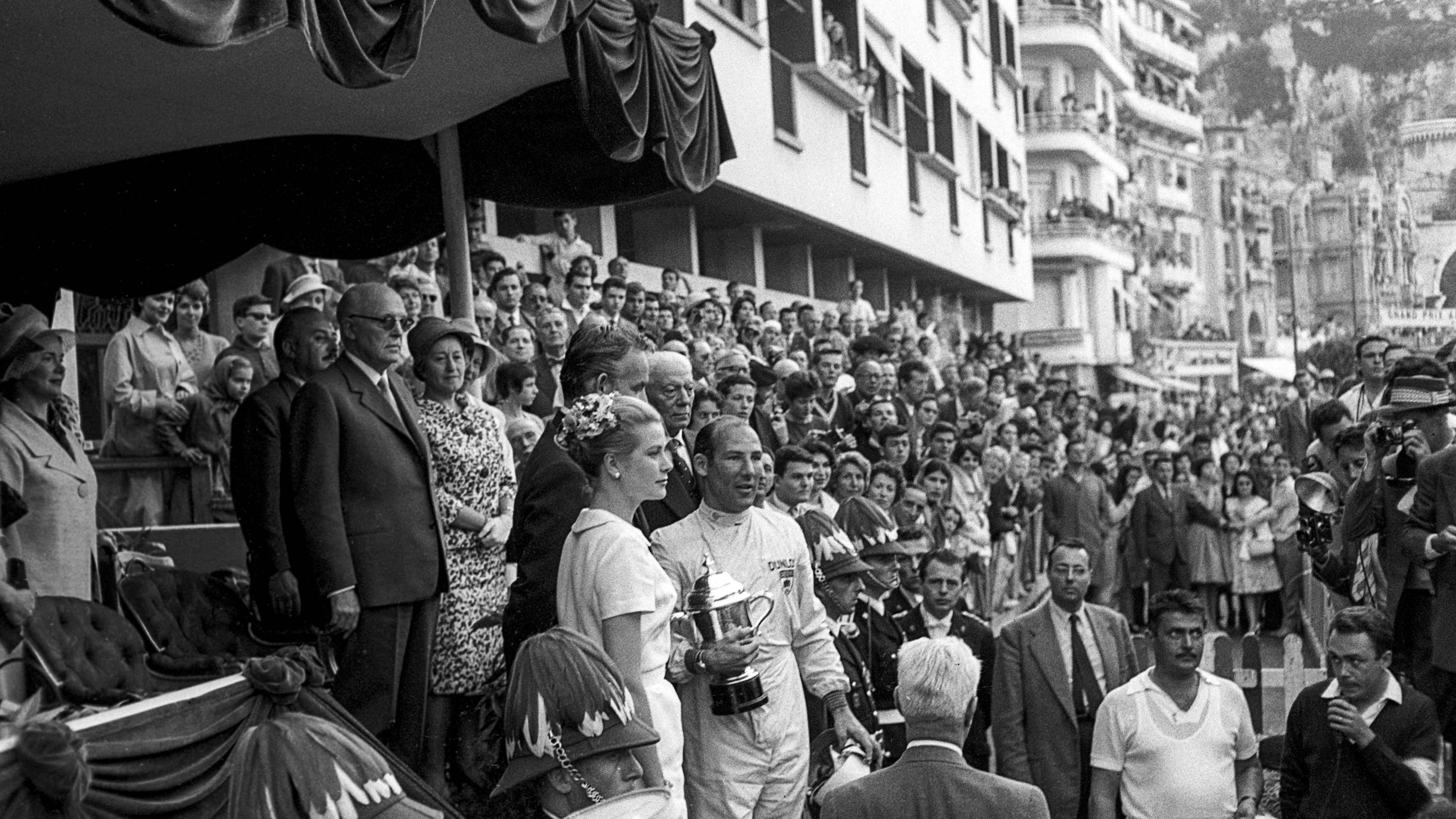 Stirling Moss segurando o troféu enquanto está ao lado da Princesa Grace de Mônaco em 1960.