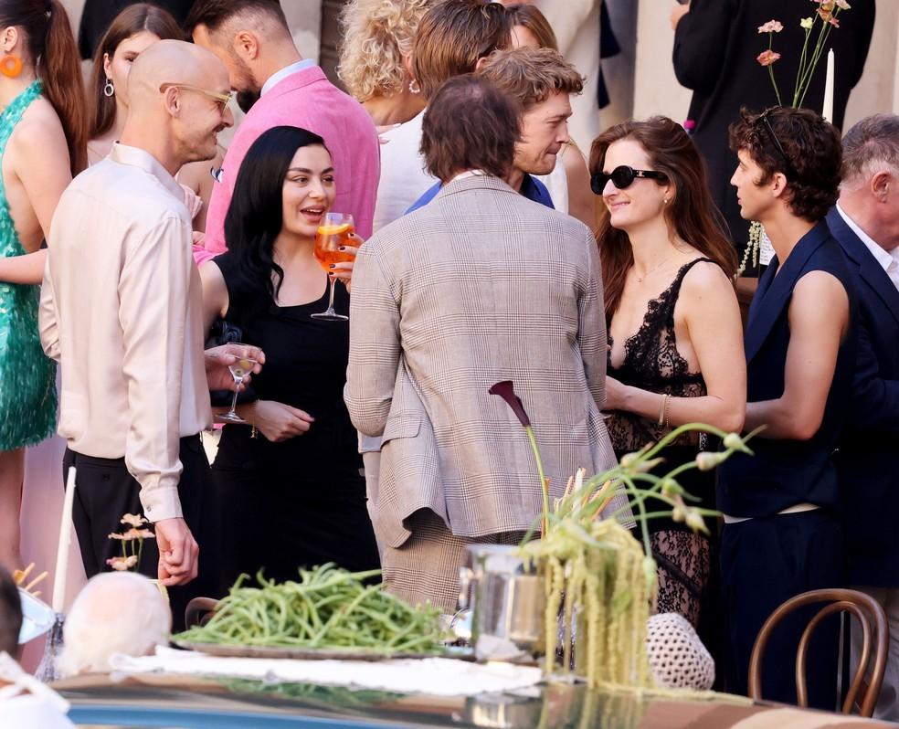 Charli XCX com amigos no casamento de Dua Lipa e Callum Turner