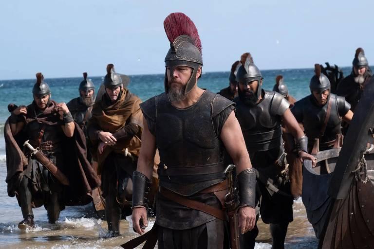 Grupo de guerreiros em direção à praia durante uma cena de 'A Odisseia'.