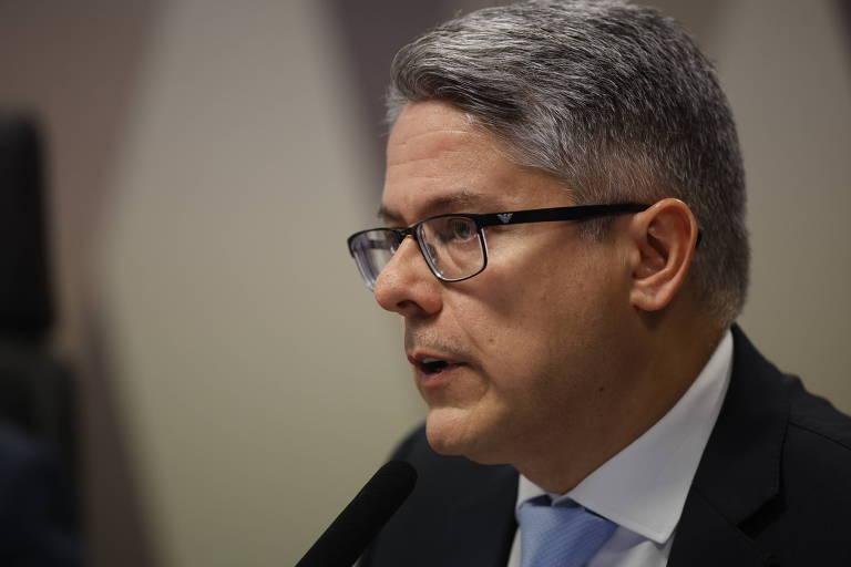 Homem de meia-idade com cabelo grisalho e óculos fala em microfone