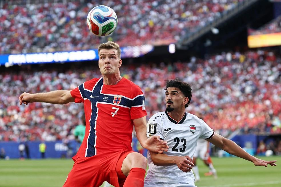 Alexander Sorloth em disputa de bola com Merchas Doski em jogo Noruega x Iraque