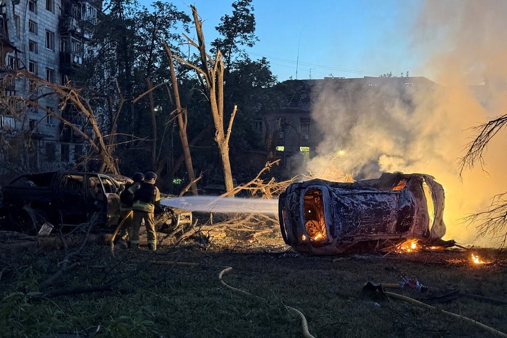 Bombeiros trabalham em prédio danificado durante o ataque