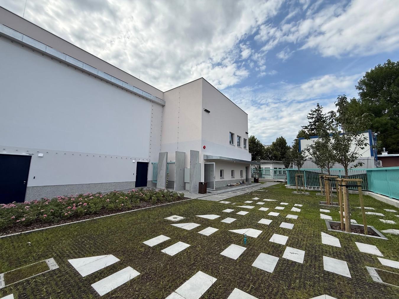 Budynek kina Tęcza com área verde ao redor