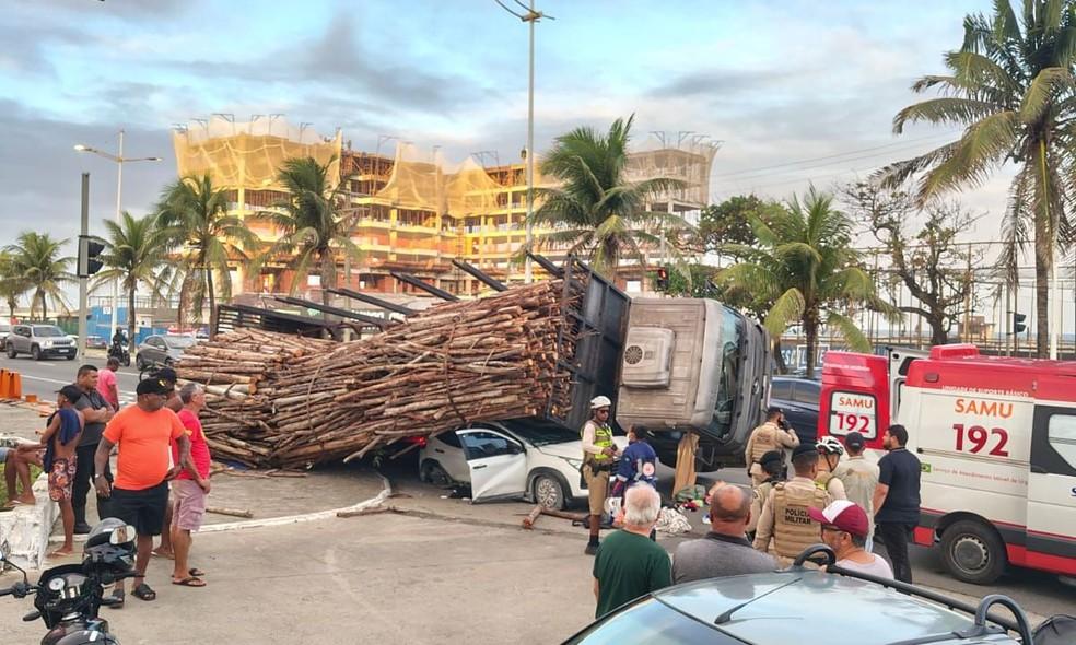 Carga de madeira cai de caminhão e causa estrago em carro em Salvador